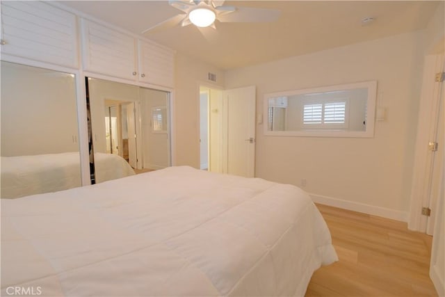 bedroom featuring ceiling fan, a closet, and light hardwood / wood-style floors