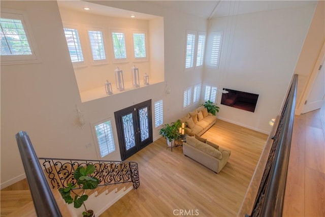 foyer entrance with a healthy amount of sunlight, wood-type flooring, and french doors