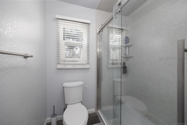 bathroom with an enclosed shower, wood-type flooring, and toilet