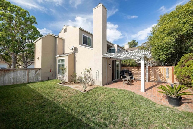 back of property with a pergola, a patio area, and a lawn