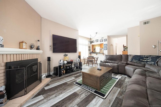 living room with a brick fireplace and hardwood / wood-style floors