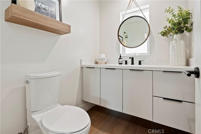 bathroom with vanity, hardwood / wood-style flooring, and toilet