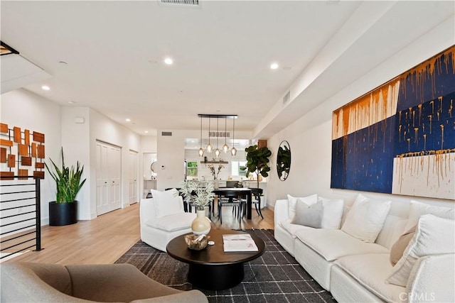 living room with wood-type flooring and an inviting chandelier