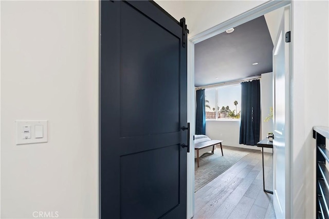 interior space with a barn door and light hardwood / wood-style floors