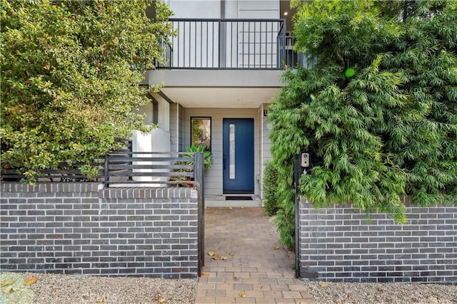 view of exterior entry featuring a balcony