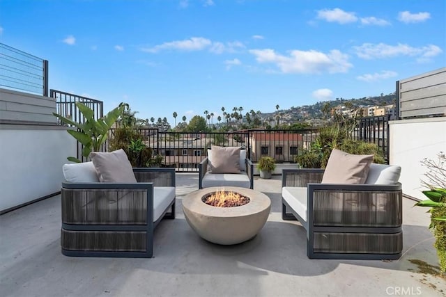 view of patio with an outdoor living space with a fire pit