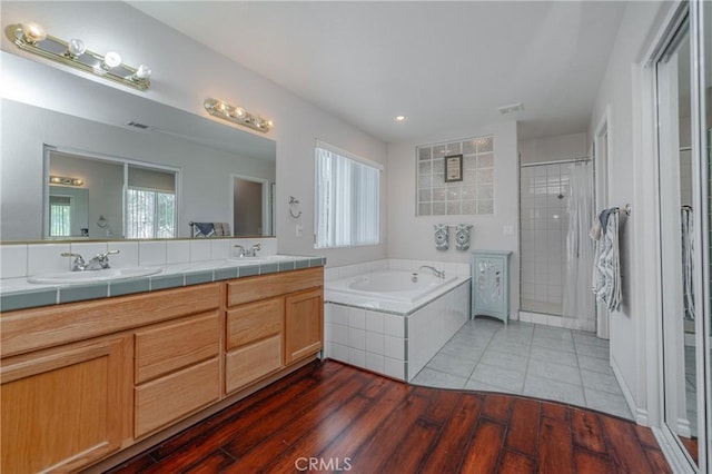 bathroom with vanity, independent shower and bath, and hardwood / wood-style flooring