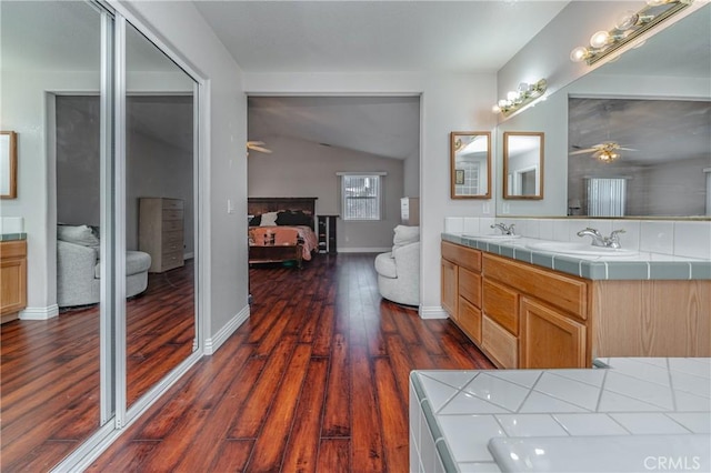 bathroom featuring ceiling fan, vanity, vaulted ceiling, and hardwood / wood-style flooring