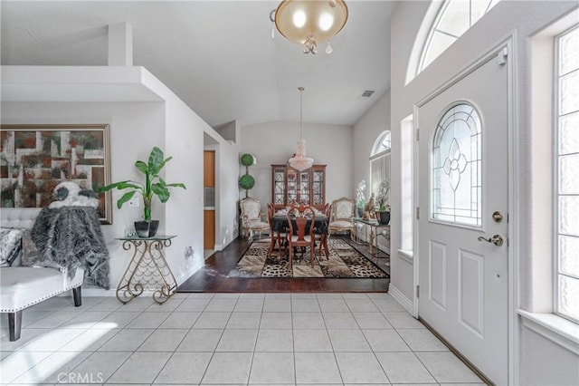 foyer with a healthy amount of sunlight, light hardwood / wood-style flooring, and vaulted ceiling