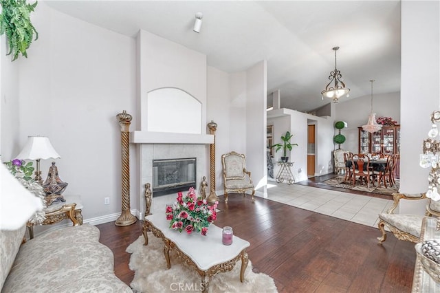 living room with a fireplace, wood-type flooring, and vaulted ceiling