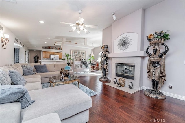 living room featuring a tile fireplace, ceiling fan, hardwood / wood-style floors, and lofted ceiling