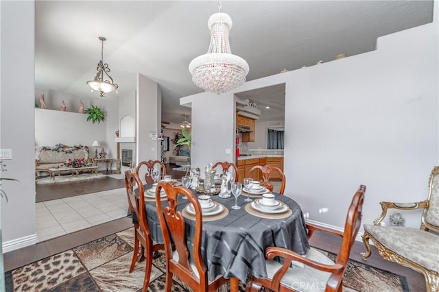 tiled dining area featuring a chandelier and lofted ceiling