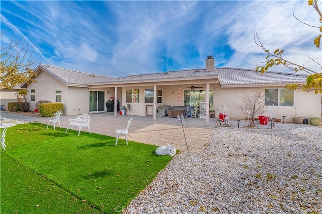 back of house with a patio, a hot tub, ceiling fan, and a lawn