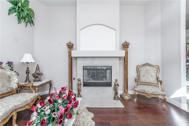 living area featuring hardwood / wood-style floors and a tiled fireplace