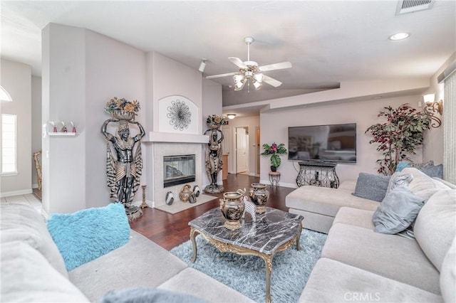 living room with ceiling fan, wood-type flooring, and lofted ceiling