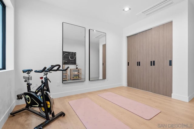 exercise room with light wood-type flooring