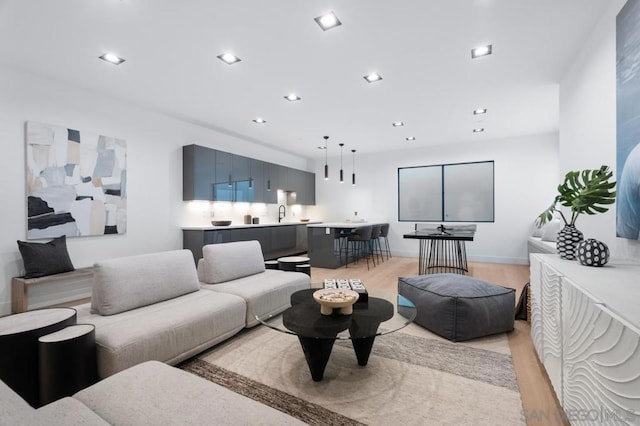 living room with light hardwood / wood-style flooring and sink