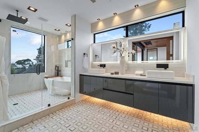 bathroom with shower with separate bathtub, vanity, and backsplash