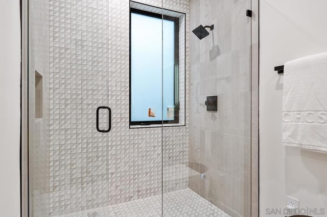 bathroom featuring a shower with shower door