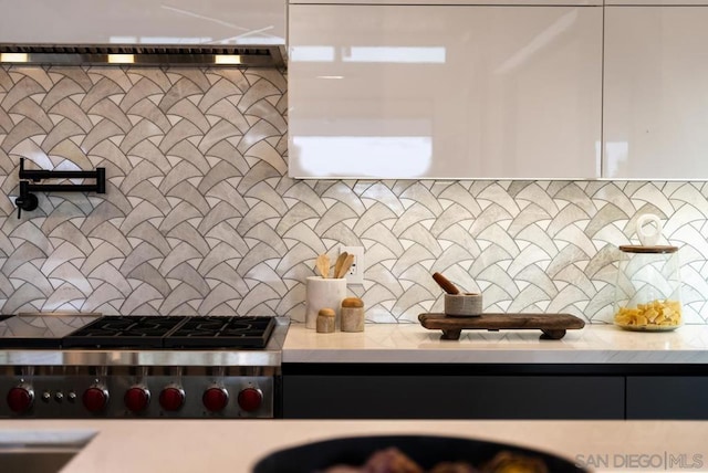 kitchen with gas stovetop, white cabinetry, and tasteful backsplash