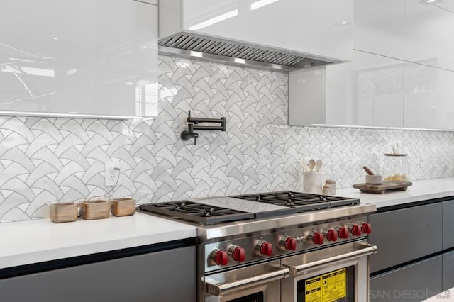 kitchen with white cabinets, custom exhaust hood, double oven range, and backsplash