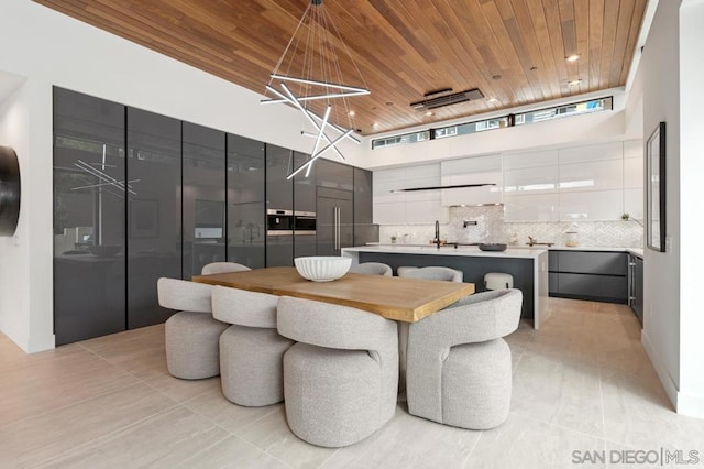 tiled dining space featuring wooden ceiling and a high ceiling