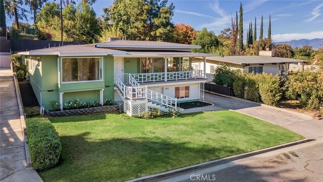 view of front of property with a mountain view and a front yard