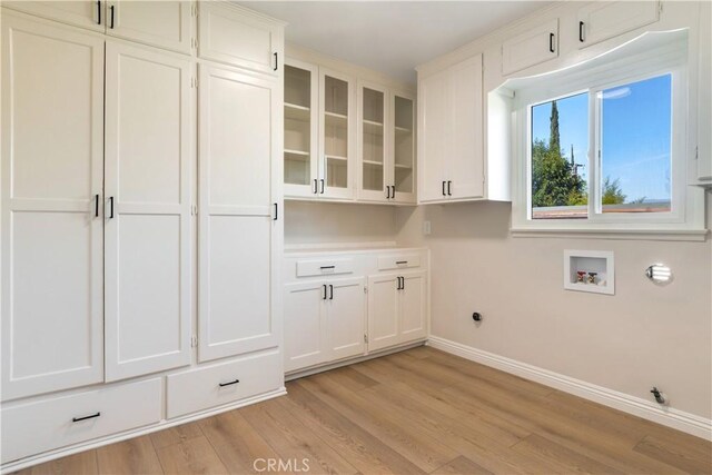 laundry room with cabinets, washer hookup, light hardwood / wood-style floors, and hookup for an electric dryer