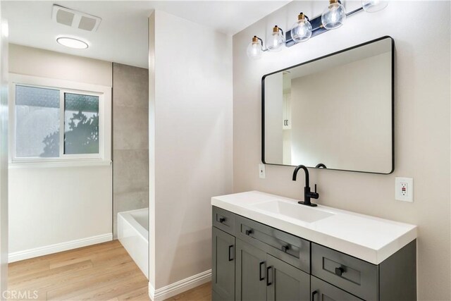 bathroom featuring shower / washtub combination, hardwood / wood-style floors, and vanity