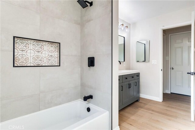 bathroom with hardwood / wood-style floors, vanity, and  shower combination