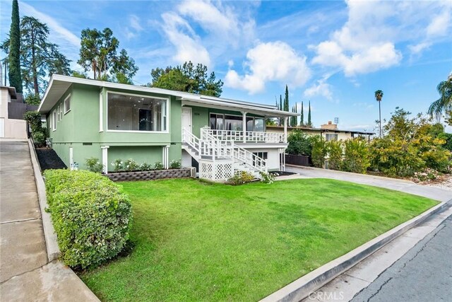 view of front of property featuring covered porch and a front lawn