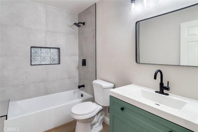 full bathroom featuring hardwood / wood-style floors, vanity, tiled shower / bath combo, and toilet