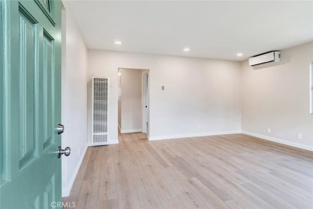 empty room with light hardwood / wood-style flooring and a wall mounted AC