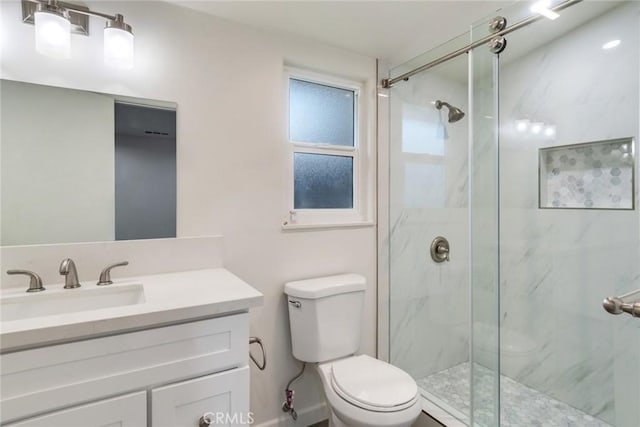 bathroom with toilet, vanity, and walk in shower