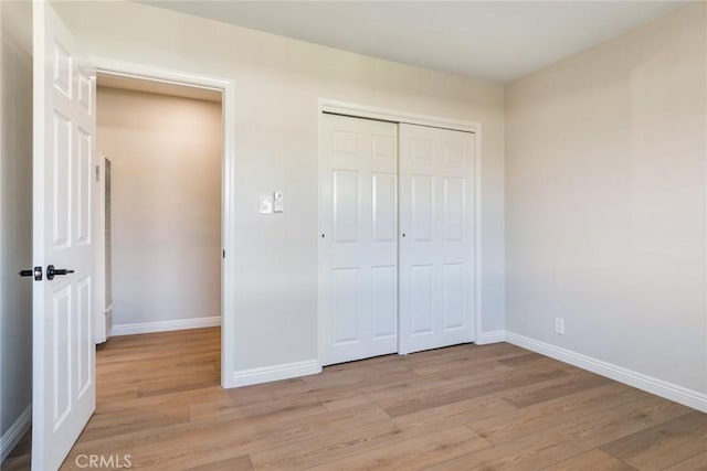 unfurnished bedroom featuring light hardwood / wood-style floors and a closet