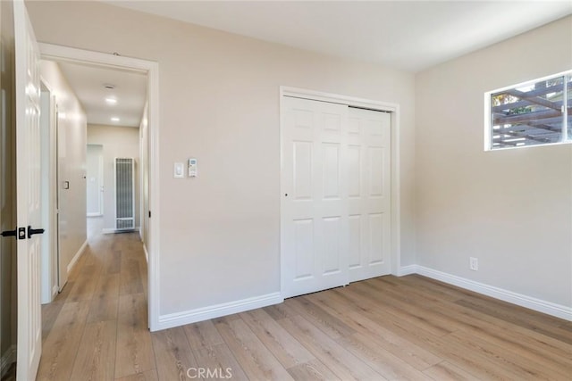 unfurnished bedroom with light hardwood / wood-style floors and a closet