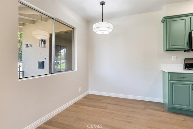 unfurnished dining area featuring a healthy amount of sunlight and light wood-type flooring