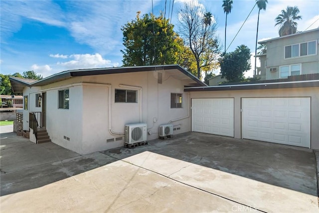 view of property exterior featuring ac unit and a garage