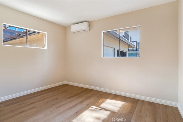 spare room featuring light hardwood / wood-style flooring and an AC wall unit