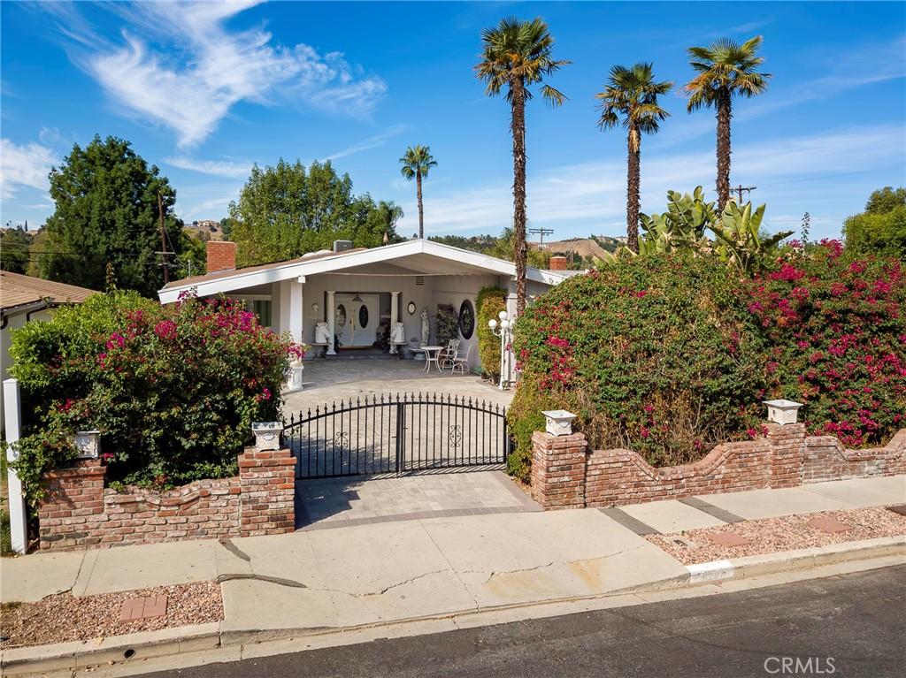 bungalow-style home featuring a chimney, fence, and a gate