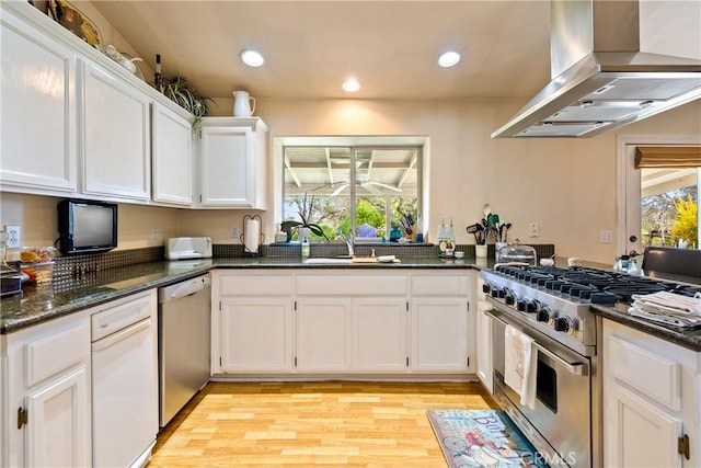 kitchen with island exhaust hood, white cabinetry, a healthy amount of sunlight, and appliances with stainless steel finishes