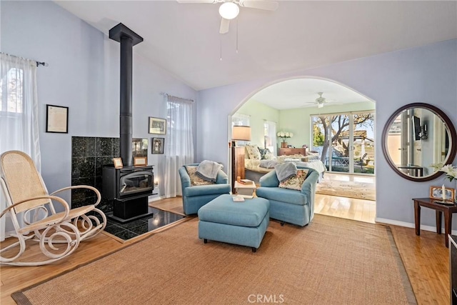 sitting room featuring a wood stove, ceiling fan, and light hardwood / wood-style floors