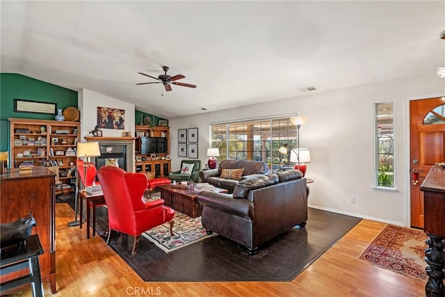 living room featuring ceiling fan, wood-type flooring, and lofted ceiling