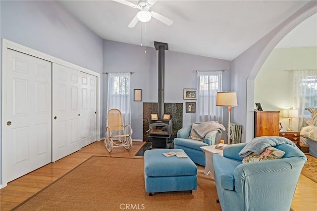 living area featuring hardwood / wood-style floors, a wood stove, and a wealth of natural light