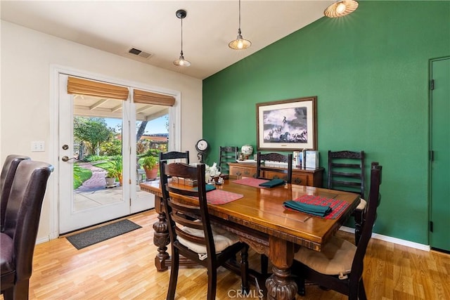 dining space featuring hardwood / wood-style flooring and lofted ceiling