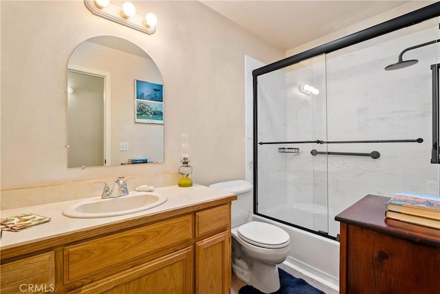 full bathroom featuring vanity, toilet, and bath / shower combo with glass door