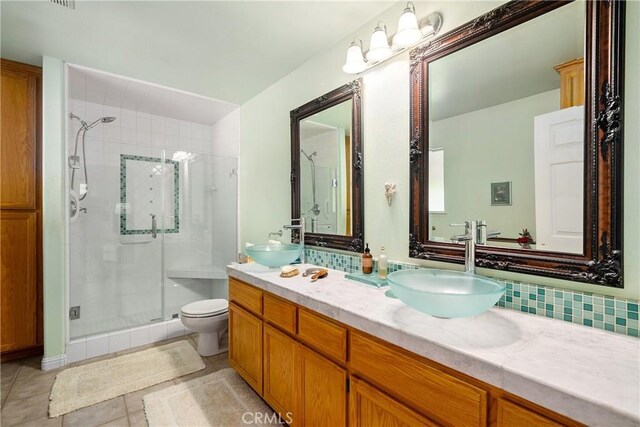 bathroom with walk in shower, tasteful backsplash, tile patterned floors, toilet, and vanity