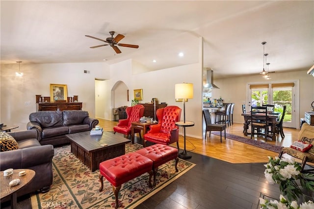 living room with ceiling fan, wood-type flooring, and lofted ceiling