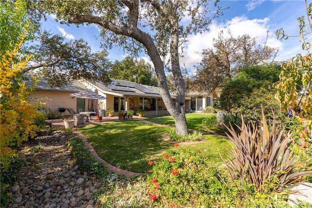 view of front of home with a patio area, a front lawn, and solar panels