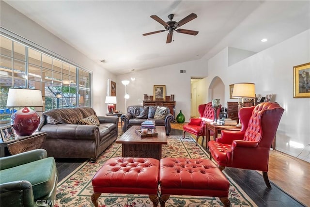 living room featuring wood-type flooring, vaulted ceiling, and ceiling fan